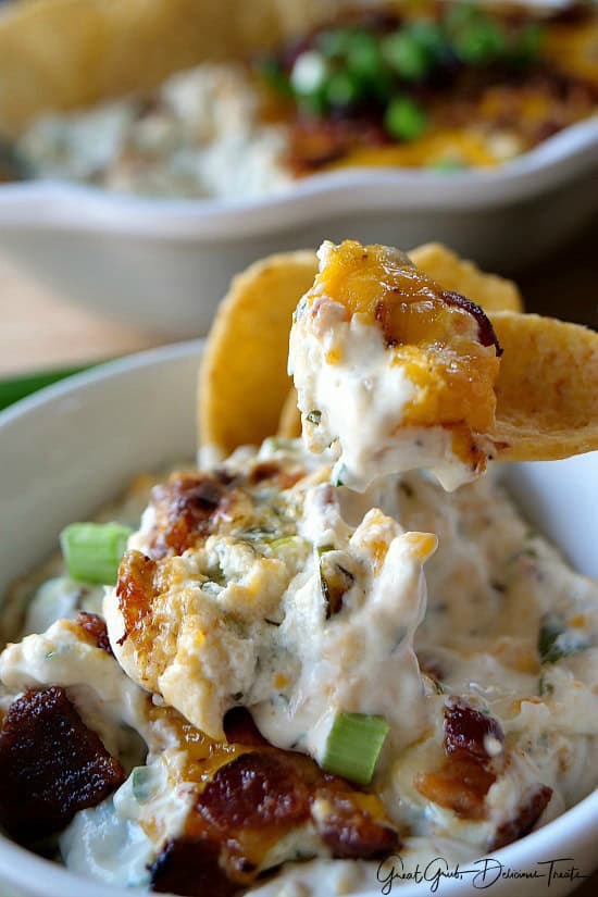 Cheesy Jalapeño Bacon Dip A close up of a corn chip that has a scoop of dip on it.