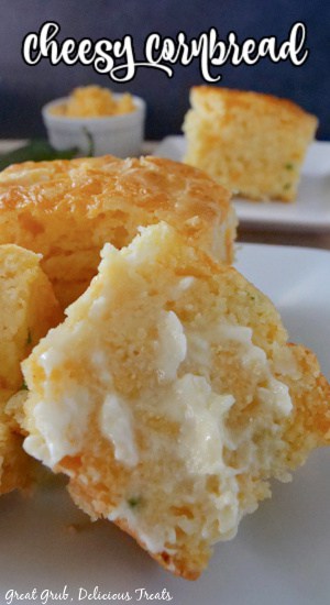 Cheesy Cornbread is loaded with diced jalapenos, sour cream, shredded cheese, and baked until golden brown. A slice of cornbread sitting on a white plate topped with melted butter.