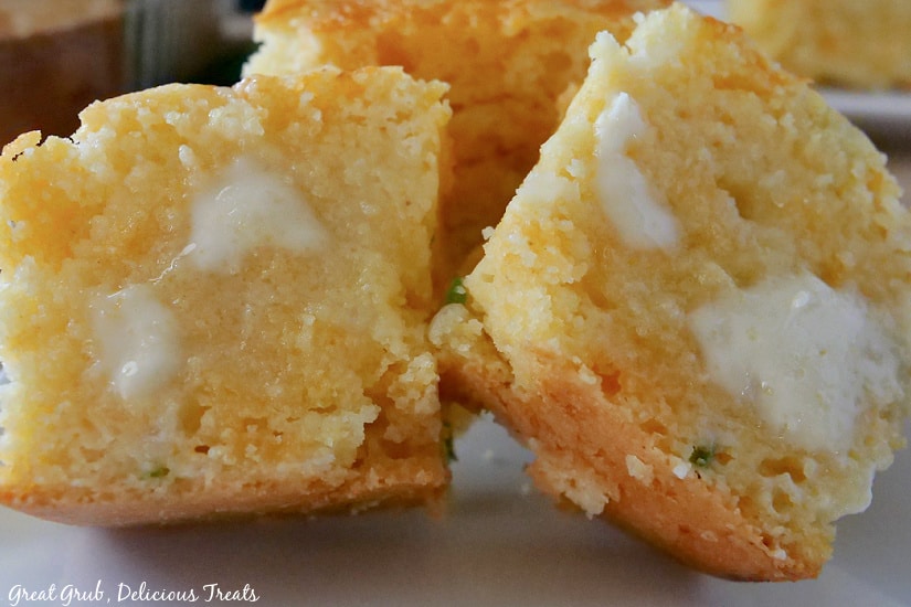 Cheesy Cornbread is a delicious cornbread recipe that is quick and easy to make. Two halves of cornbread with melted butter on it.
