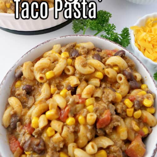 A close up photo of a white bowl with brown trim filled with taco pasta, with the title at the top of the pic.