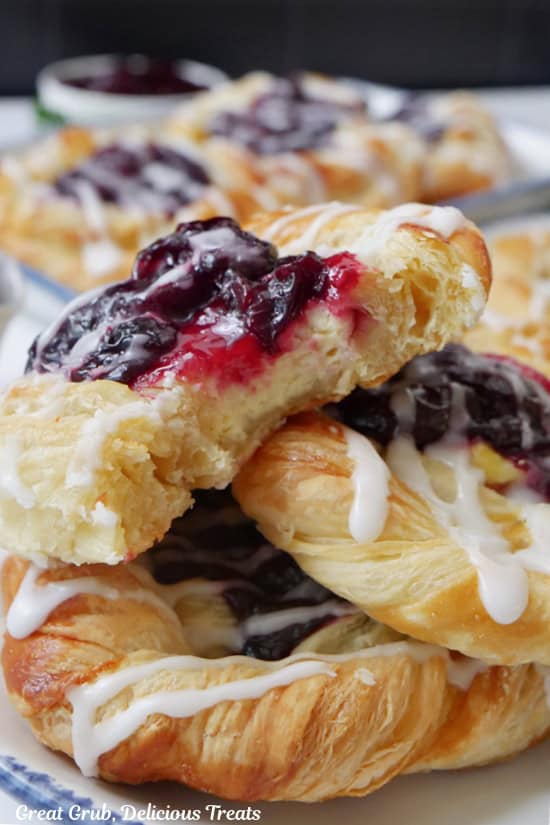 Three pastries stacked on top of each other with a couple bites taken out of the one on top.