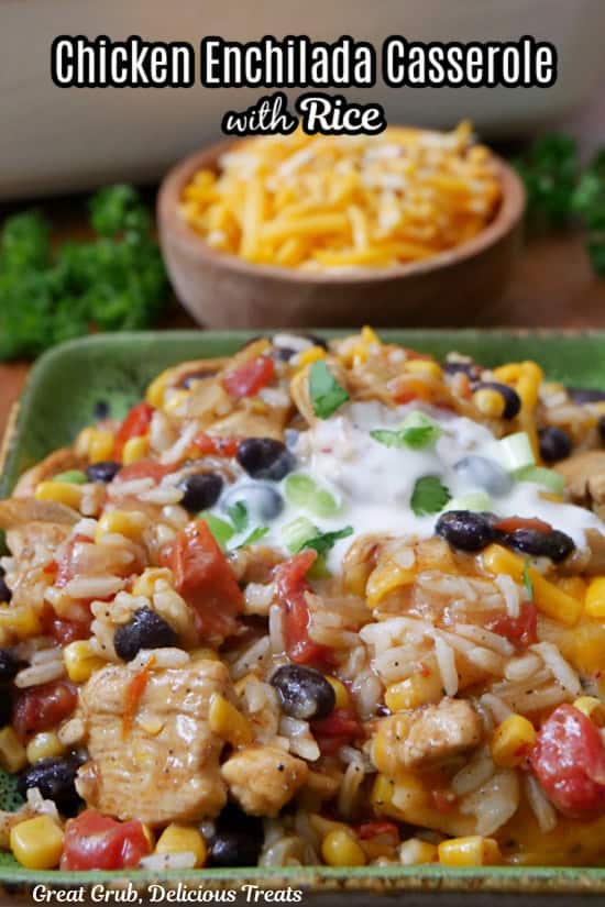 A square green plate with a serving of chicken enchilada casserole, rice, beans, corn with sour cream on top.