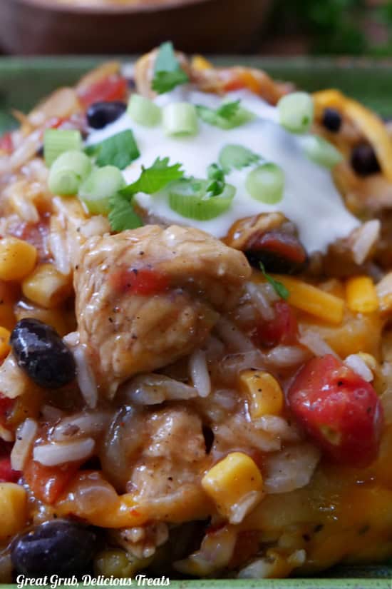A close up of chicken, rice, corn, beans, sour cream.