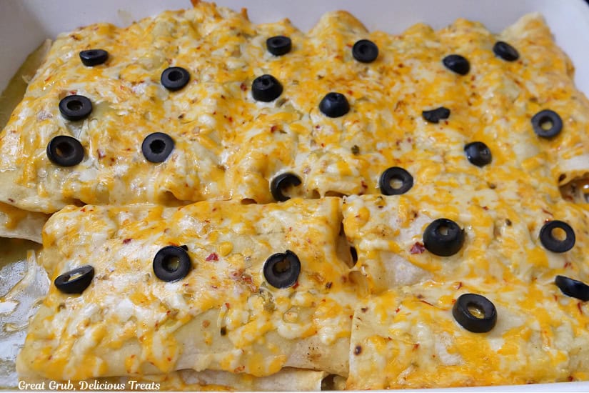 A white baking dish filled with chicken enchilada after being removed from the oven.