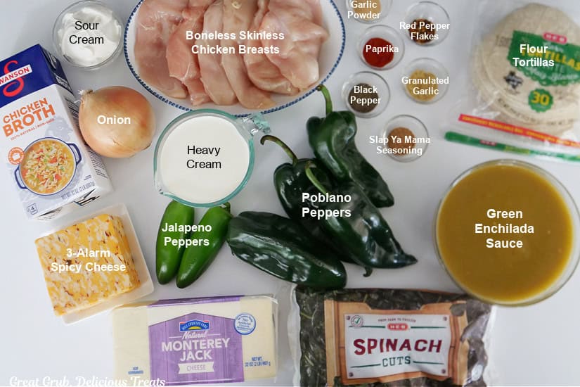 All of the ingredients needed to make chicken poblano enchilada casserole placed on a white surface.