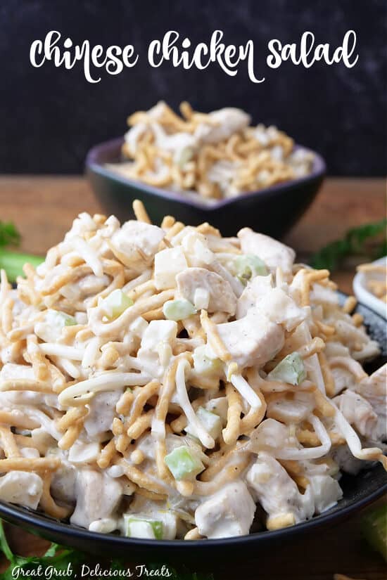 A black bowl with Chinese chicken salad in it.