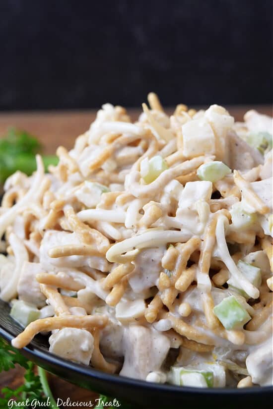 A close up of a black bowl filled with crunchy Chinese chicken salad.