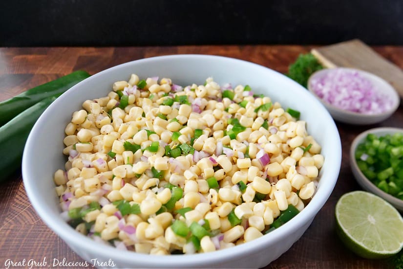 Chipotle Fresh Tomato Salsa is loaded with crunchy white corn, freshly diced jalapeños and red onions, cilantro, lime juice, and some seasonings. A landscape photo of salsa in a large white bowl.