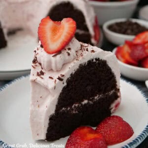 A slice of chocolate strawberry cream bundt cake on a round white plate with blue trim.