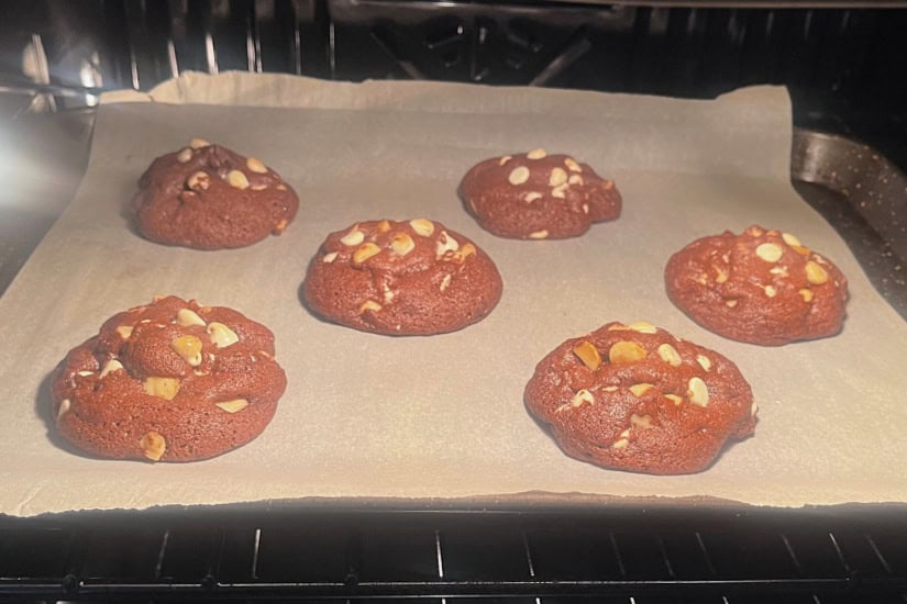 Chocolate macadamia nut cookies in the oven baking.