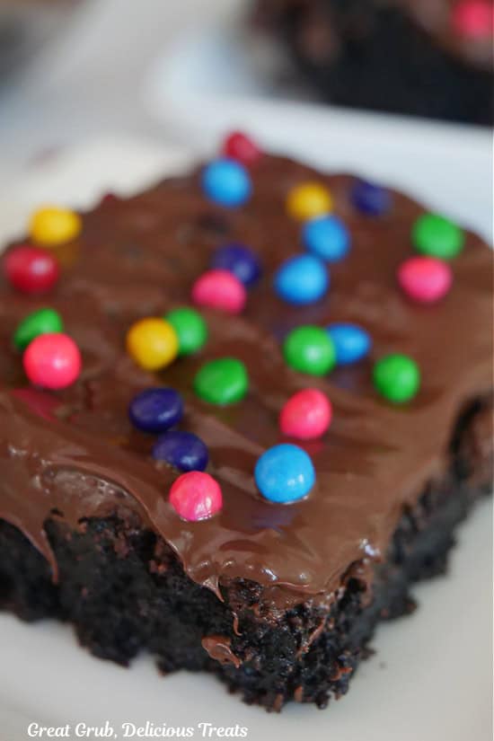 A serving of a chocolate brownie on a white plate.