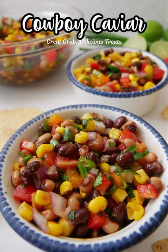 Two white round bowls with blue trim  and a clear glass bowl filled with cowboy caviar.