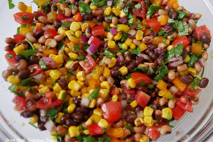 All of the ingredients in a clear glass bowl after being mixed together.