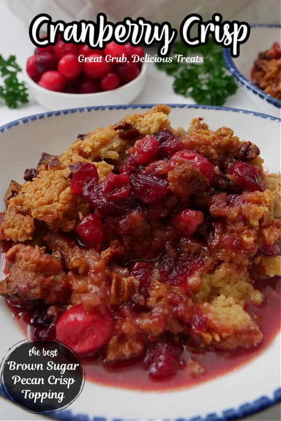 A white bowl with blue trim filled with a serving of cranberry crisp.