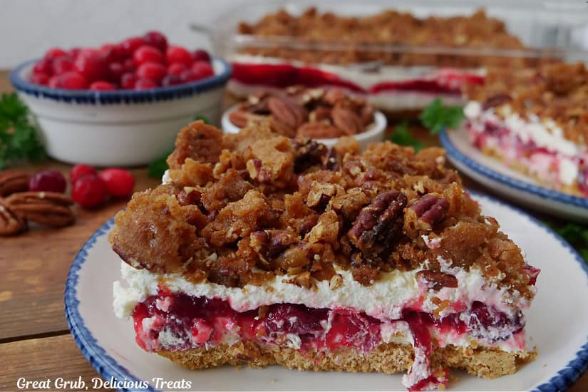 A wood surface with two round plates with a serving of cranberry orange dessert on them.
