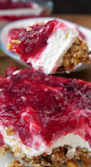 A close up bite of cranberry pretzel salad on a spoon.