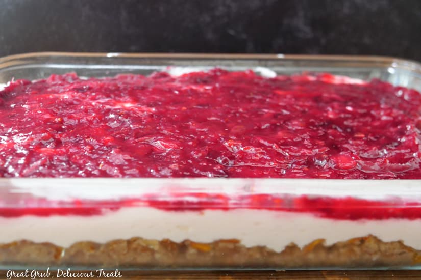 A horizontal photo of a 9 x 13 baking dish with cranberry pretzel salad in it.
