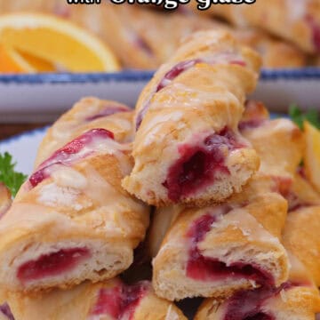A stack of cranberry twists stacked on top of each other showing the cranberry filling inside the crescent dough, and the title overlay at the top.