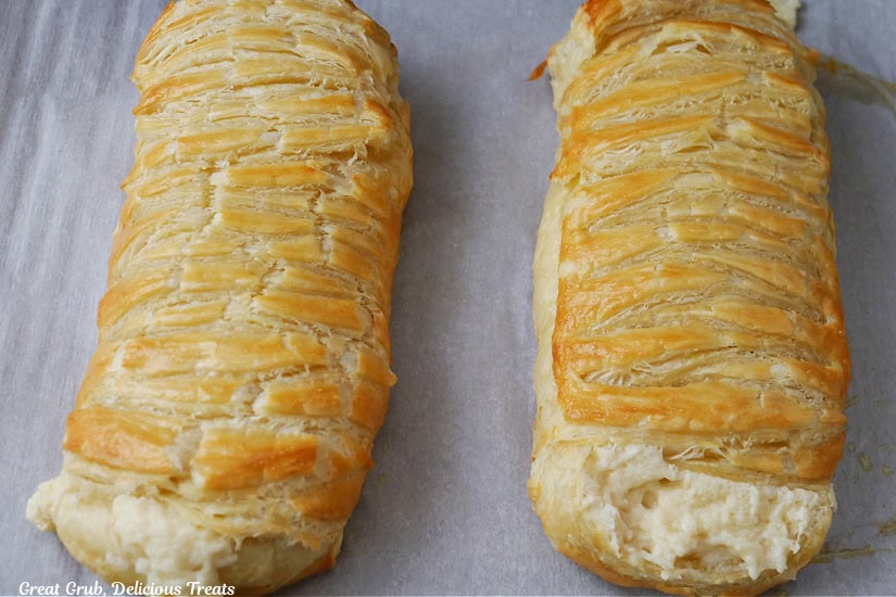 Two cheese pastry braids on a baking sheet after being removed from the oven.