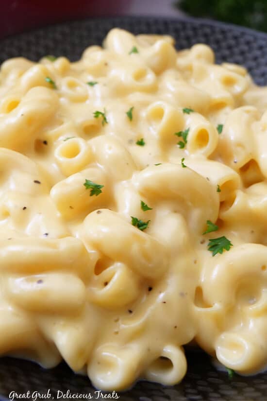 A close up of a serving of mac and cheese in a black bowl.