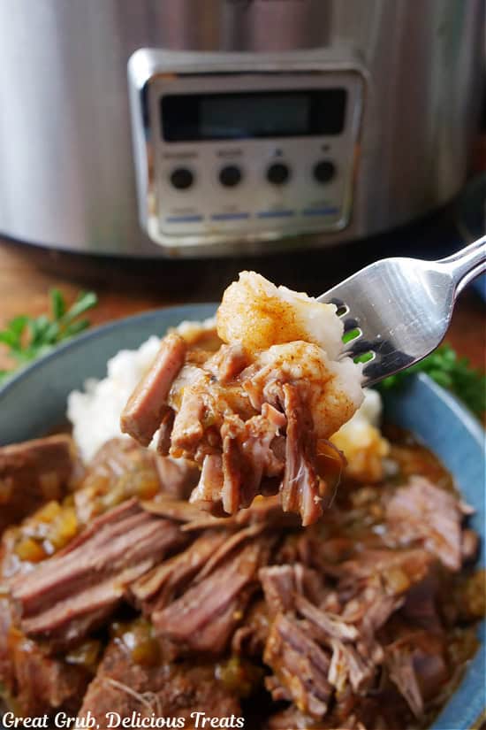 A bite of crock pot beef shoulder roast and mashed potatoes on a fork.