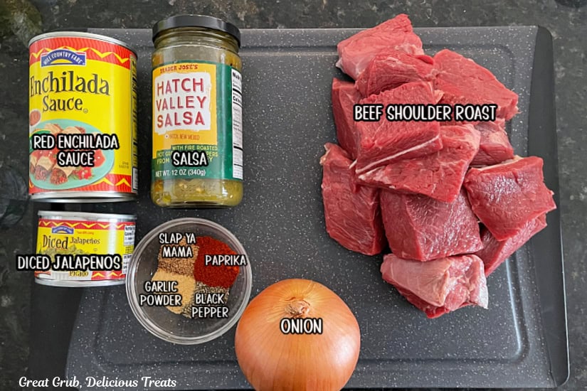 A black cutting board with all the ingredients on it with the names of the ingredients on top of each item.