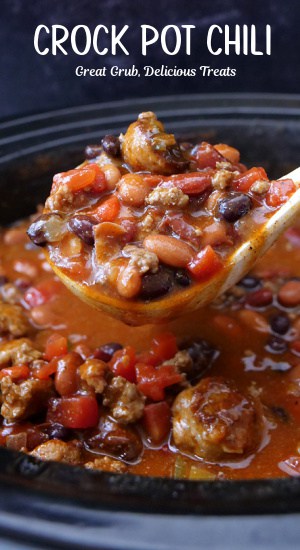 A crock pot filled with chili and a ladle scooping out a serving.