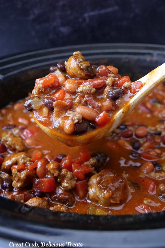 A ladle scooping out a serving of homemade chili.