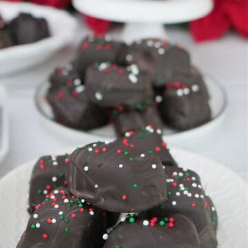 A white surface with dark chocolate covered caramels on white plates with the title overlay at the top.
