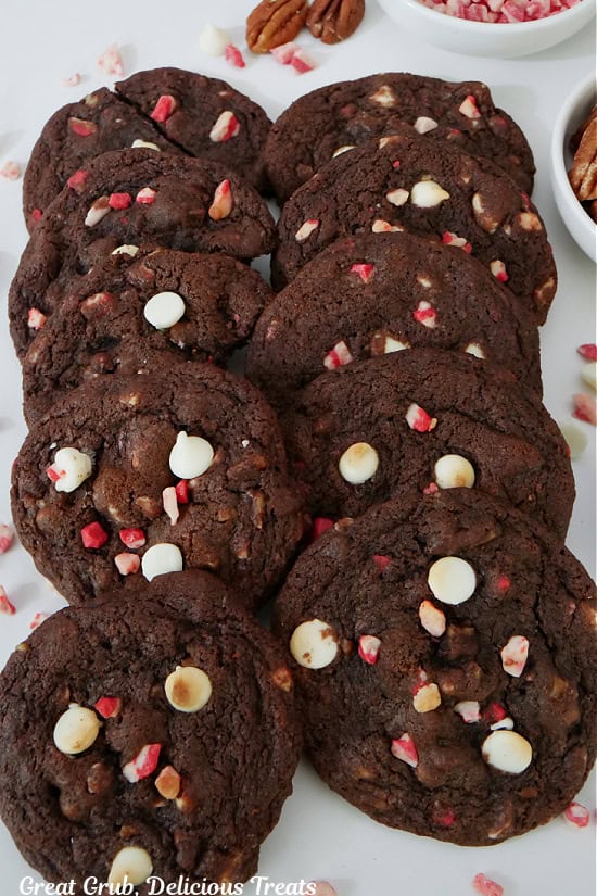 Eight dark chocolate cookies on a white surface.