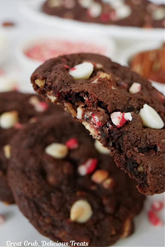 Three cookies on a white surface with a bite out of one of the cookies.