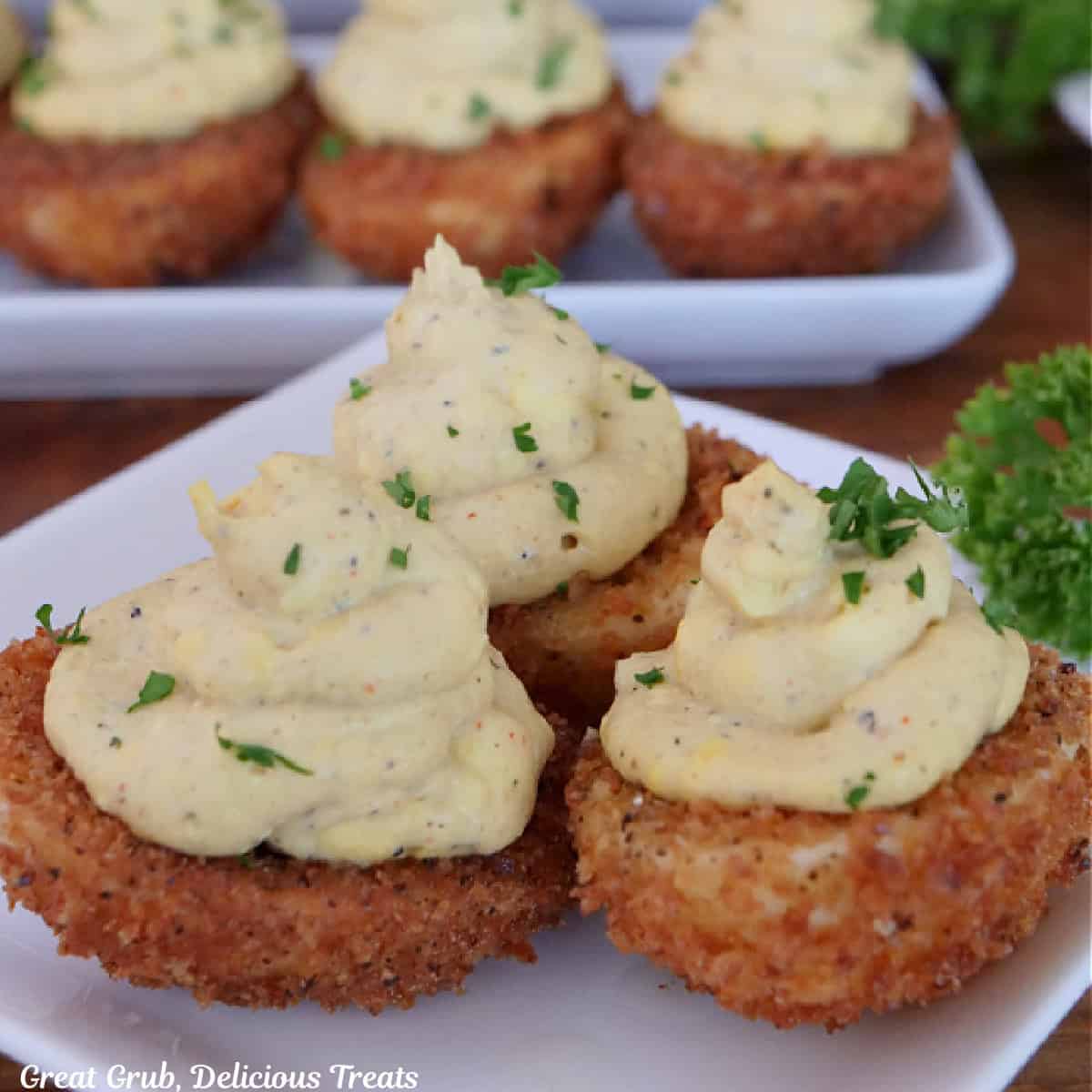 A white plate with three crispy deviled eggs on it.
