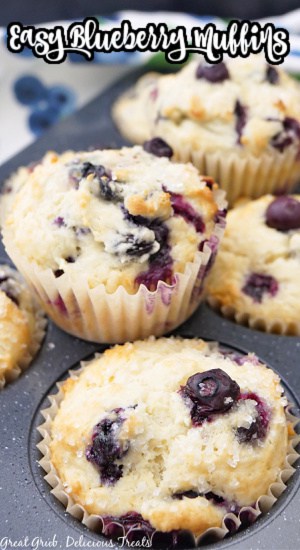 A muffin tin with blueberry muffins in it.