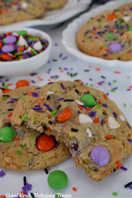 A white surface with two Halloween cookies on it with a bite taken out of one of them.