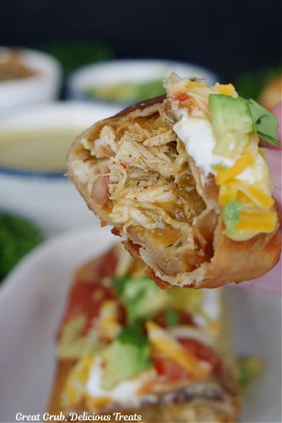 A fried chicken burrito cut in half showing the inside ingredients.