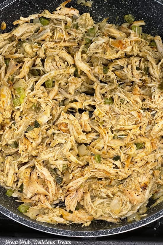 A pan with cooked shredded chicken mixture in it.