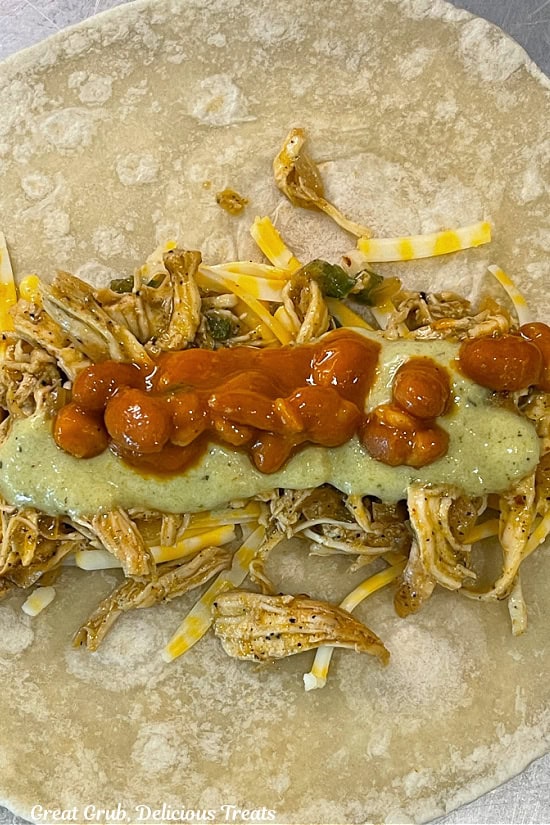 Ranch beans and poblano sauce added to shredded chicken and cheese on top of a flour tortilla.