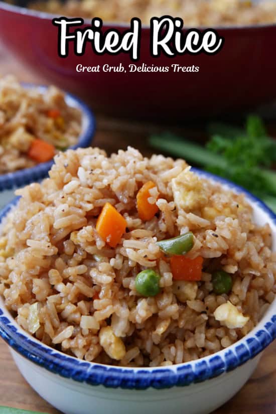A white bowl with blue trim filled with a serving of fried rice.