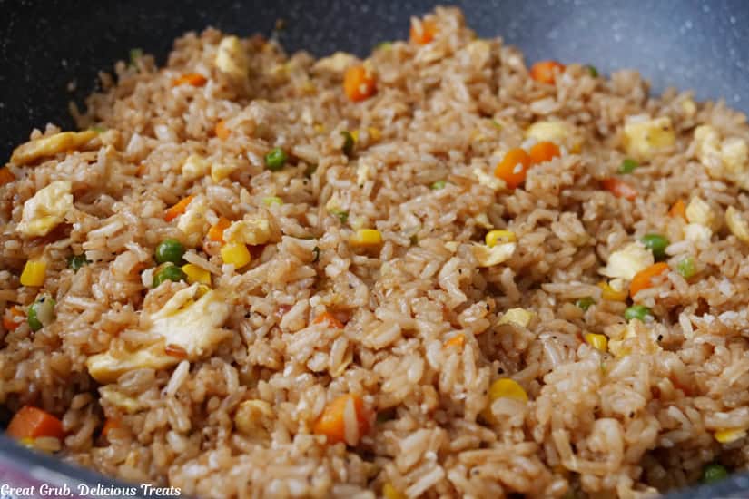 A skillet with homemade fried rice in it.