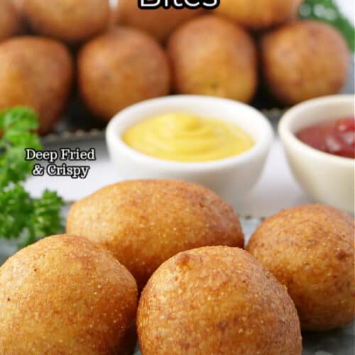 A silver tray with four sausage bites on it, two small bowls of dip in the back, and a large tray of bites in the background.