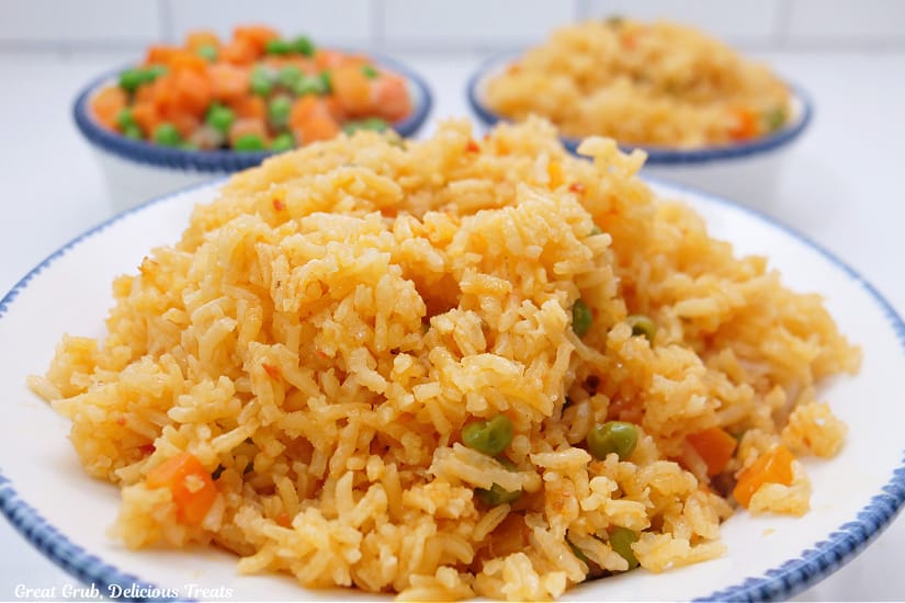 A horizontal photo of a white bowl with blue trim filled with a serving of rice.