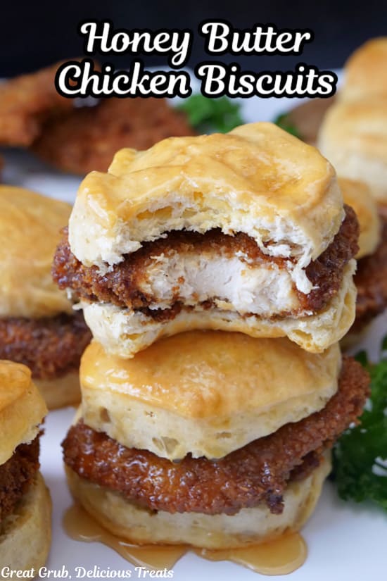 Two honey butter chicken biscuits stacked on top of each other with a bite taken out of the top one.