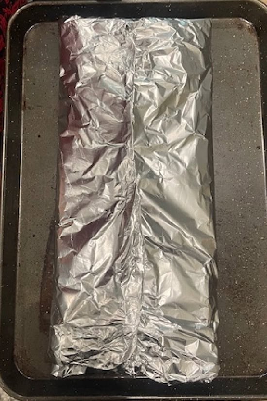 A foil packet on a baking sheet.