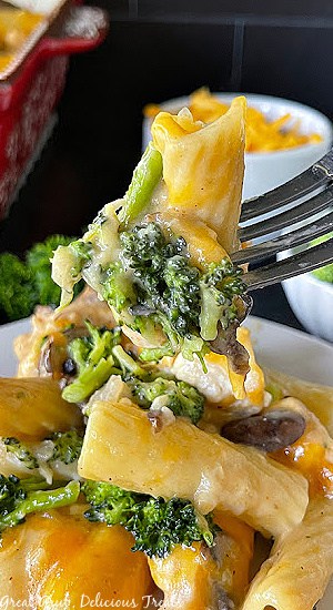 Chicken Broccoli Casserole is a quick and easy recipe to whip up for weeknight dinners. A white plate with chicken and broccoli casserole on it with a bite sitting on a fork.