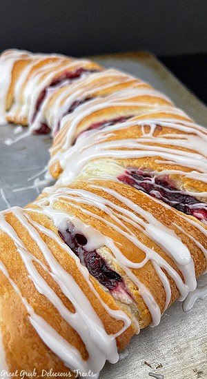 A baking sheet showing half of a cranberry cheese pastry ring.