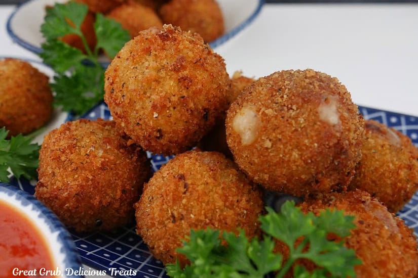 A blue plate with a stack of Italian sausage bites on it.