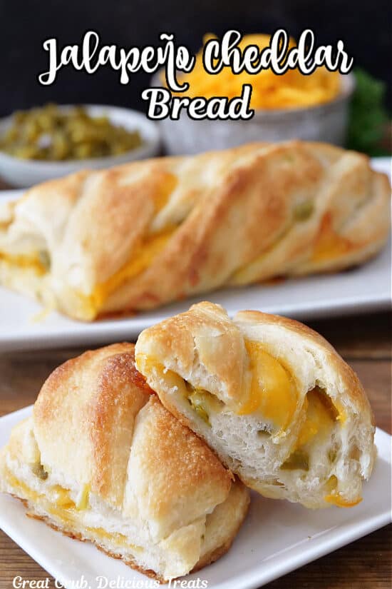 Two white plates with two slices of cheese bread on one and half the loaf on the other plate.