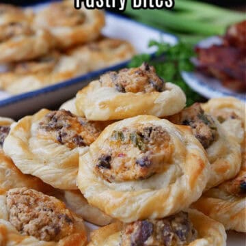 A white plate with blue trim filled with about a dozen bite-size jalapeno popper pastries on it.