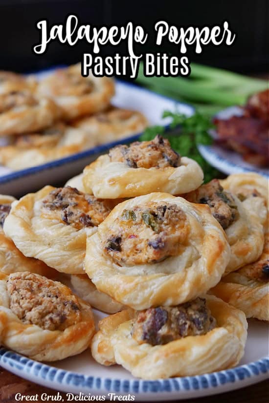 A white plate with blue trim filled with about a dozen bite-size jalapeno popper pastries on it.