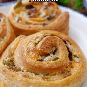 A close up of jalapeno popper pinwheels on a white plate with blue trim.